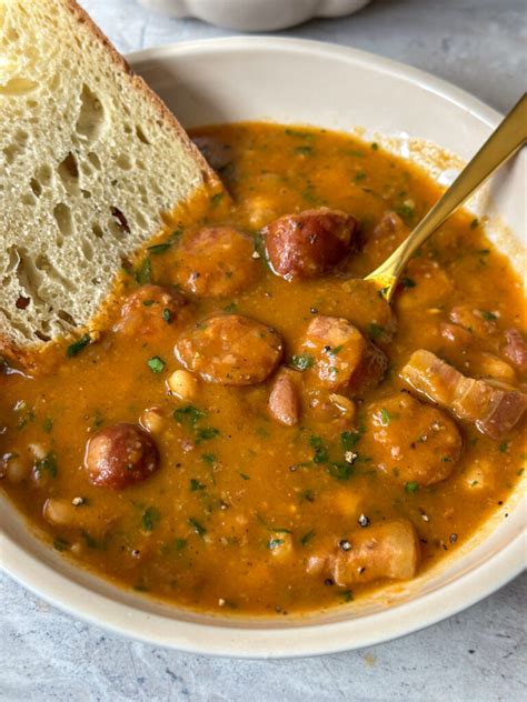 A bowl of traditional pasulj with smoked ribs, served with fresh bread