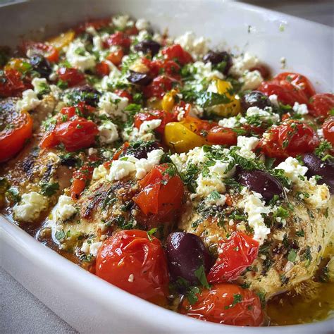 Oven-baked chicken with green beans, tomatoes, olives, and feta cheese in a baking dish