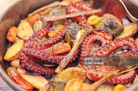Close-up photo of baked octopus and potatoes in a baking dish