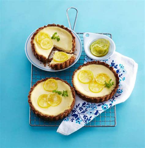 Fotografija pečene limonine torte s piškotnim dnom in lemon curdom, okrašena s smetano
