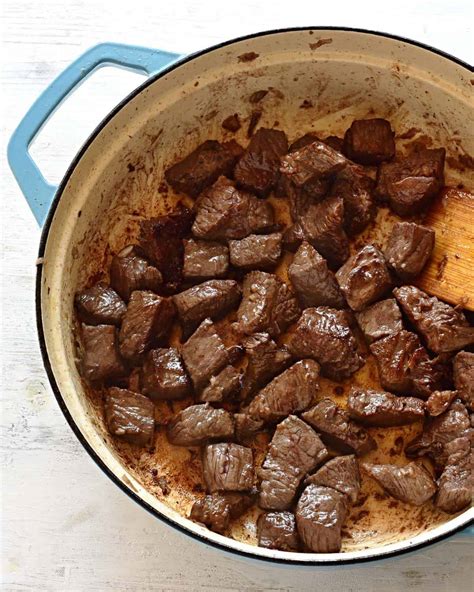 Step-by-step photo of browning beef cubes in a pot