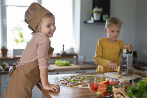 Otroci okrasijo pice z različnimi sestavinami