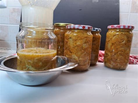slika korenčkove marmelade v kozarcih, okrašene s cimetovo paličico in rezinami limone