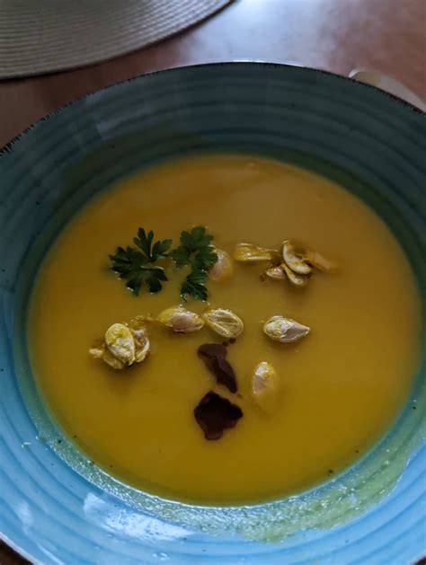 fotografija bogato obložene bučne juhe s semeni in smetano