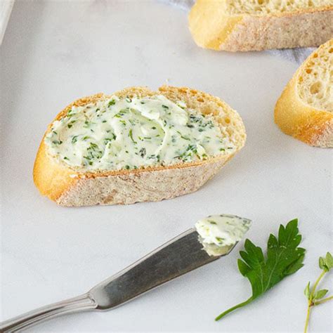 postreženo zeliščno maslo na kosu pečenega kruha