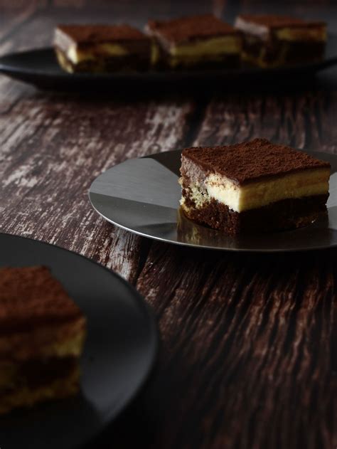 Fotografija klasičnega tiramisuja v stekleni posodi, postreženega s kakavom v prahu