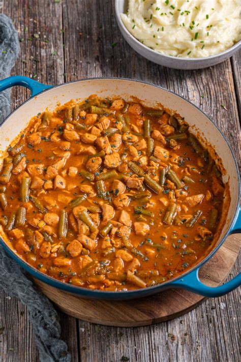 Fotografija rdečega tajskega curryja s piščancem in rižem