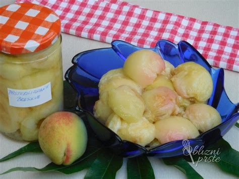 Fotografija zapolnjenih kozarcev s slivami, pripravljenih za pasterizacijo