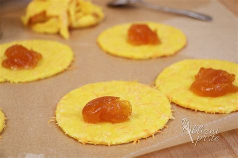Majhni, zlato zapečeni piškotni žepki, napolnjeni z rdečo marmelado