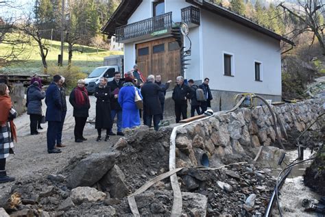 Prikaz kmetije Lojz v Poljanski dolini z njivami in okoliškim hribovjem
