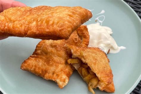 Slika ohlajene jabolčno-pudingove pite, narezane na kose, pripravljene za postrežbo.