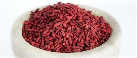 Fotografija rdečega kvasnega riža v prahu in zrnatih oblikah.