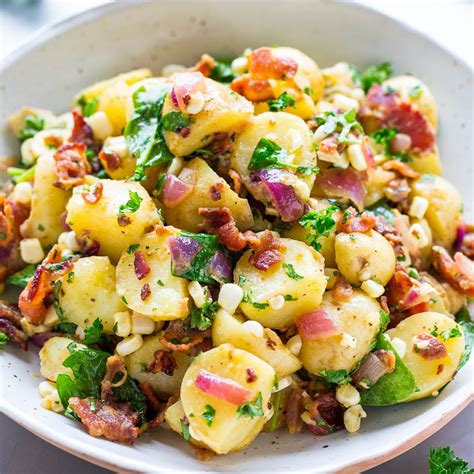 Thematic photo of a large bowl of cold potato salad with chicken, carrots, and peas