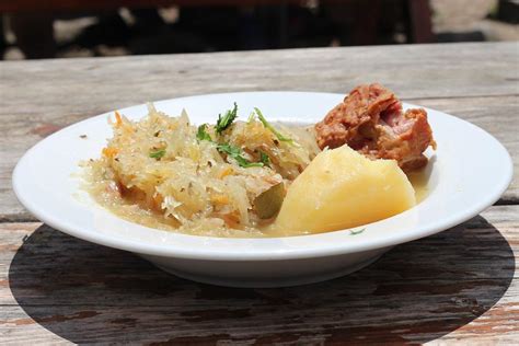 Sestava tradicionalne poljske enolončnice bigos: kislo in sveže zelje, različne vrste mesa, klobase, suhe gobe in slive.