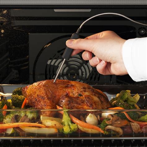 Preverjanje temperature pečenega piščanca s termometrom