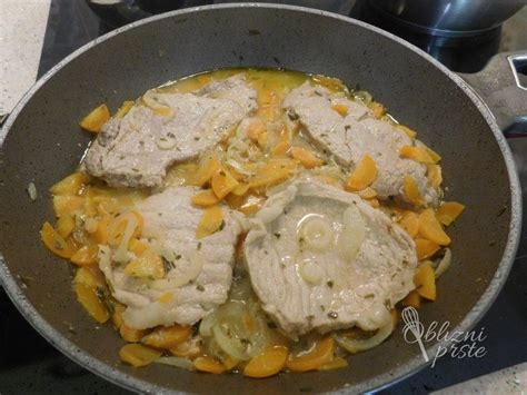 Pekač s svinjskim vratom v omaki, obložen s korenjem in čebulo