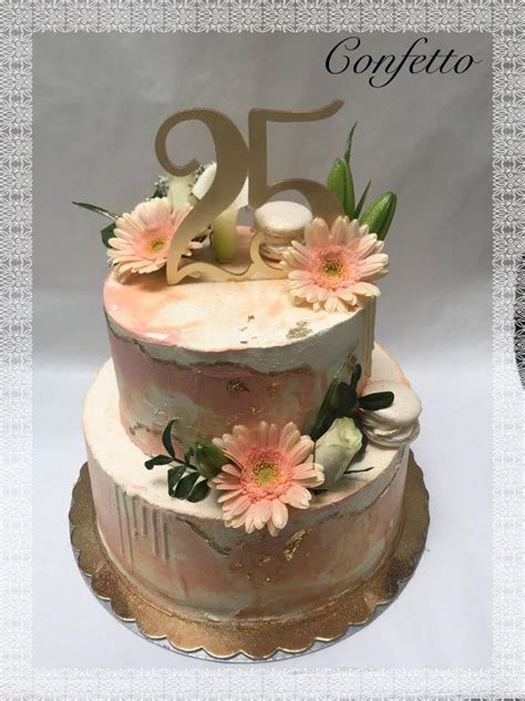 Fotografija elegantne, večnadstropne torte, okrašene s svežimi cvetlicami ali zlatimi detajli, primernimi za visok jubilej.