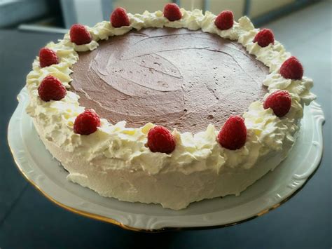 Sestavine za čokoladno torto z malinami, razporejene na delovni površini.