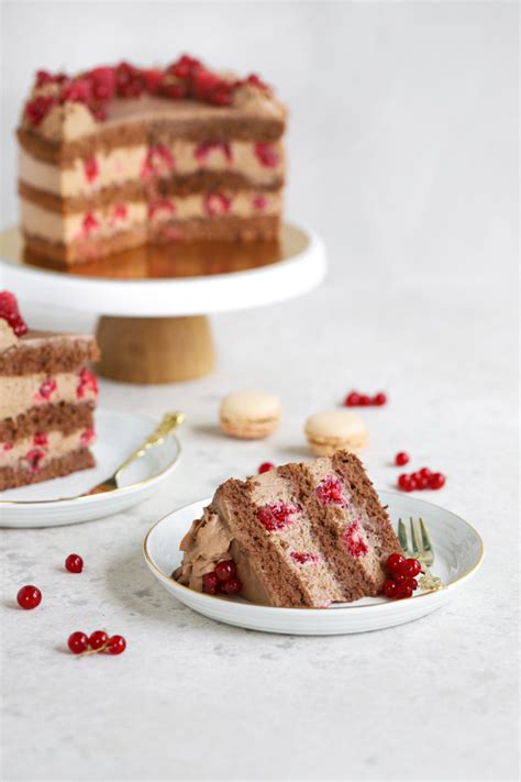 Plasti čokoladne torte z malinami, ki se sestavljajo v tortnem modelu.