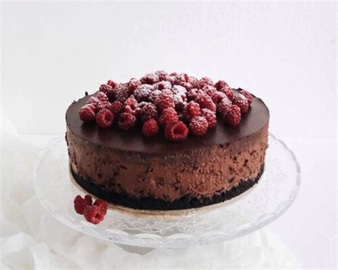 Končana čokoladna torta z malinami, pripravljena za postrežbo.