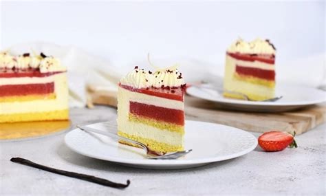 slika prereza Raffaello torta z jagodami, ki prikazuje plasti biskvita, kreme in jagodnega želeja