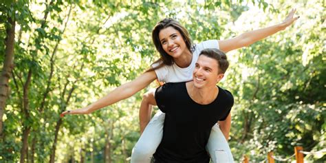 mlad par, ki se smehlja ob pripravi testeninskega obroka