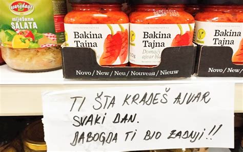 Prikaz napolnjenih in zaprtih kozarcev ajvarja, ovitih v brisačo