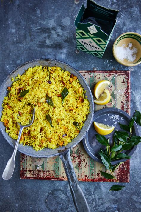 A beautifully plated dish of Lemon Rice with fresh curry leaves, garnished with cilantro.