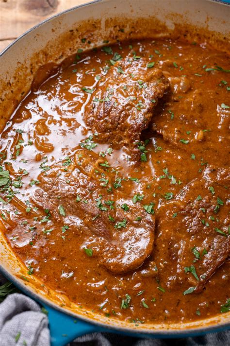 pripravljeni goveji zrezki v šampinjonovi omaki s polnozrnatimi špageti, postreženi na krožniku