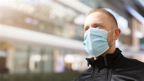 Fotografija pokopališča z žalujočimi, ki nosijo maske