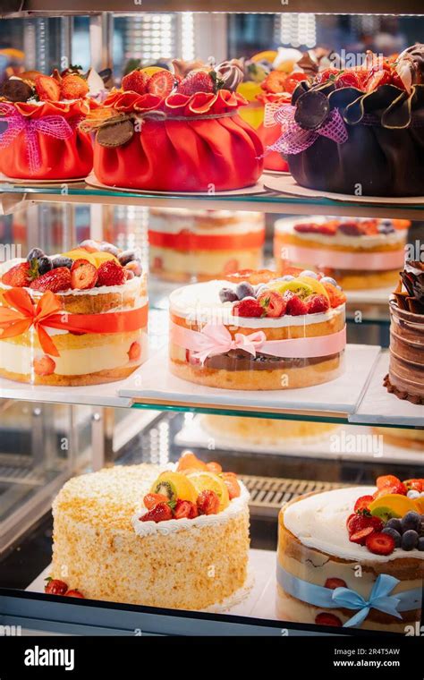 Thematic photo of various cakes and pastries in a display case of a modern confectionery