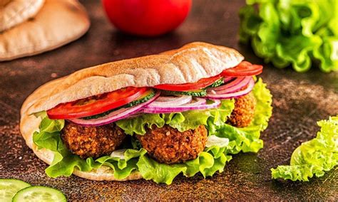 Tematska fotografija falaflov v pita kruhu z zelenjavo in omakama