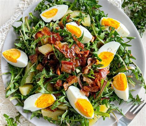 Pripravljena solata s krompirjem, grahom in tunino, okusno okrašena s paradižnikom in olivami.