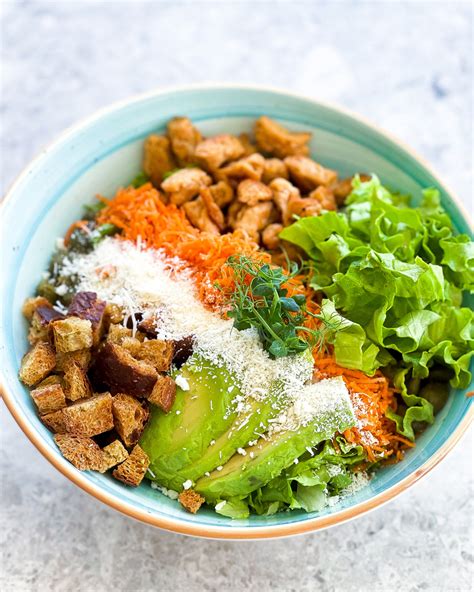 Narezana zelena v skledi, pripravljena za mešanje z jogurtovim prelivom.