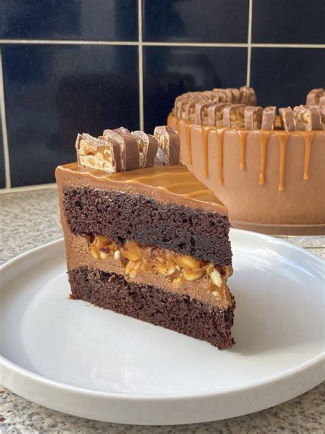 Thematic photo of a slice of Snickers cake with caramel and peanuts