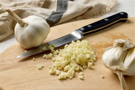 fotografija črnega česna na leseni deski