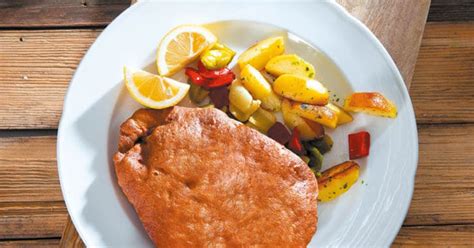 Puranji zrezki v zlato zapečenem pivskem testu, postreženi z limono