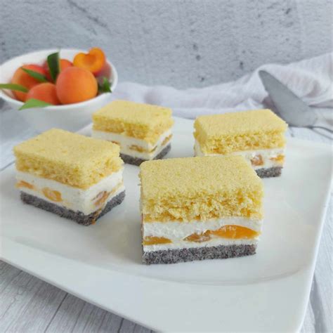 Fotografija servirane rezine jogurtove torte z marelicami na krožniku.